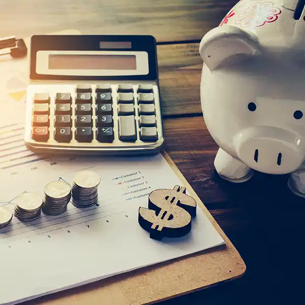 Calculator, piggy bank, and financial documents on a desk